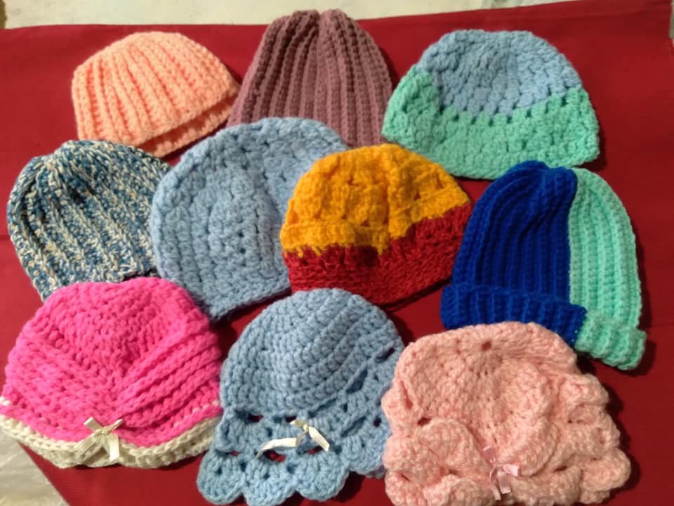 Gorritos de lana de distintos colores apoyados en una mesa.