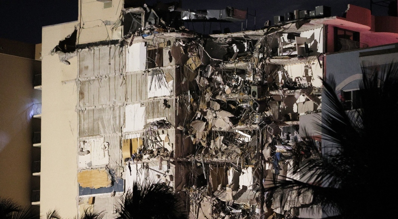 Dos torres de edificios, una de las cuales se muestra parcialmente derrumbada.