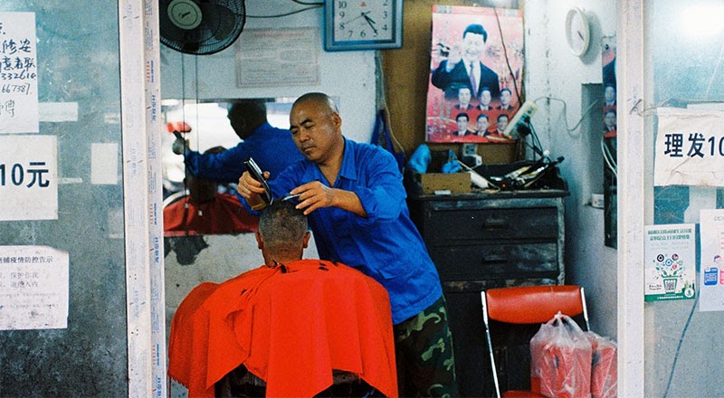 Foto de un peluquero que corta el cabello en China.