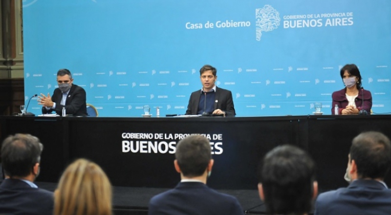 Tres personas dan una conferencia de prensa. En el medio, el gobernador Axel Kicillof.