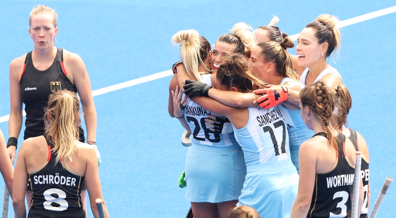 Jugadoras argentinas de hockey festejan abrazadas, mientras que las alemanas se lamentan.