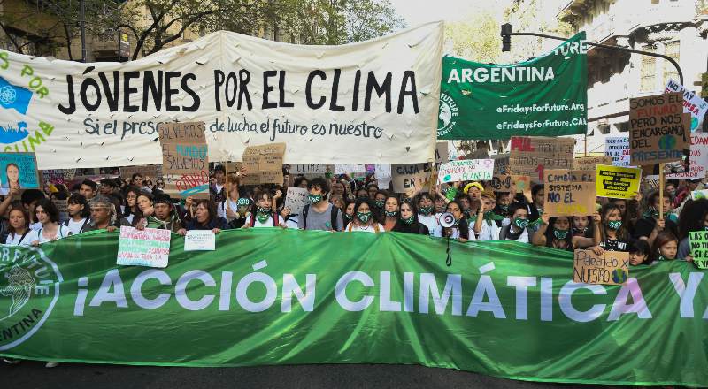 Jóvenes se movilizan con banderas en reclamo por acción climática en Buenos Aires.