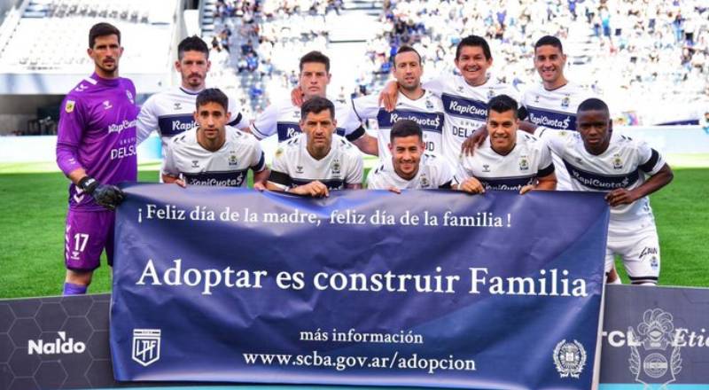 Un equipo de fútbol sostiene el banner de la campaña de adopción en la provincia de Buenos Aires.