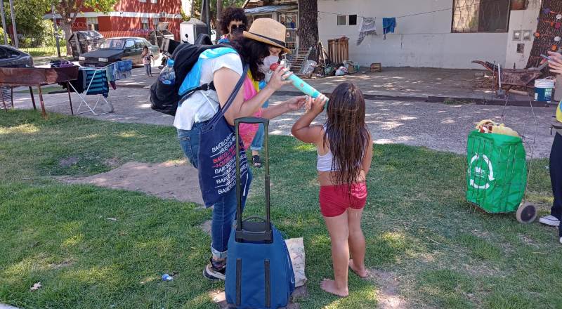 Una de las integrantes de Libros en el barrio susurra un poema a una niña.