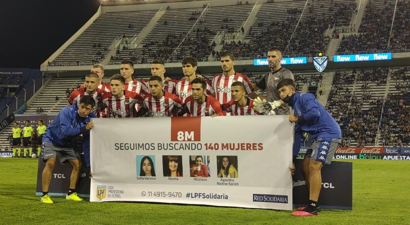 Jugadores de Estudiantes posan con un flyer sobre la búsqueda de mujeres perdidas.