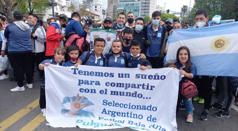 Karen junto con miembros del seleccionado de fútbol de tala baja. Sostienen una bandera de una campaña de inclusión.